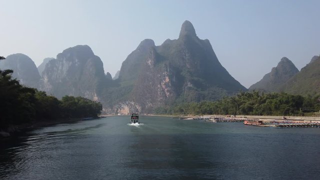Boat on Li river cruise and karst formation landscape in the fog between Guiling and Yangshuo, Guangxi province, China