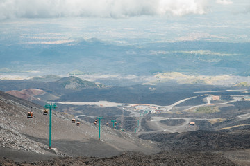 Top of crater Mount Etna volcano, frozen cold lava smokes, thick clouds