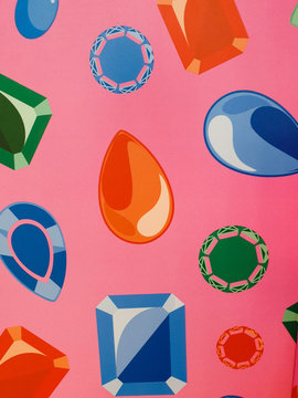 Printings of blue, green and coral red diamond shaped embellishments on pink wallpaper background