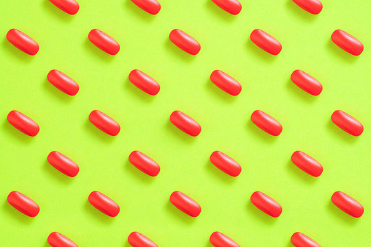 Pattern Of Red Pills On A Green Background. Pain Pill Concept.