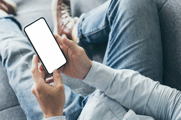 Mockup image blank white screen cell phone.men hand holding texting using mobile on desk at home office.background empty space for advertise text.people contact marketing business,technology 