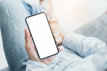 Mockup image blank white screen cell phone.men hand holding texting using mobile on desk at home office.background empty space for advertise text.people contact marketing business,technology 