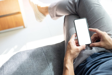 Mockup image blank white screen cell phone.men hand holding texting using mobile on desk at home office.background empty space for advertise text.people contact marketing business,technology 