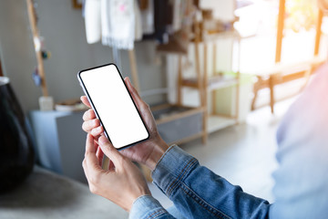 Mockup image blank white screen cell phone.men hand holding texting using mobile on desk at home office.background empty space for advertise text.people contact marketing business,technology 