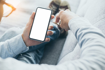 Mockup image blank white screen cell phone.men hand holding texting using mobile on desk at home office.background empty space for advertise text.people contact marketing business,technology 