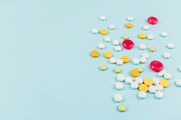Colorful pills on a pastel blue background. Flat lay, top view, overhead, mockup, template. Pharmacy and medical concept