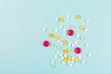 Colorful pills on a pastel blue background. Flat lay, top view, overhead, mockup, template. Pharmacy and medical concept