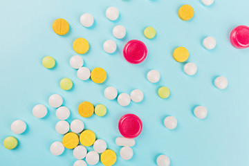 Colorful pills on a pastel blue background. Flat lay, top view, overhead, mockup, template. Pharmacy and medical concept