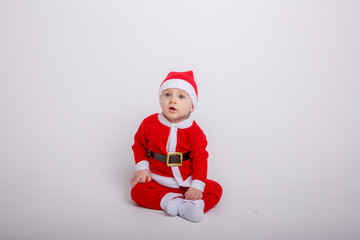 Fototapeta na wymiar a baby in a Santa Claus costume on a white background