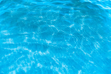 Blue transparent sea water near the beach texture background. clear water surface with slight waves...
