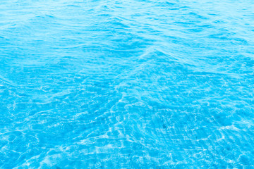 Blue transparent sea water near the beach texture background. clear water surface with slight waves...
