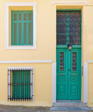 Athens Greece, vintage house facade with green door and windows on ocher wall
