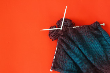 knitted sweater with white skewers on the red background