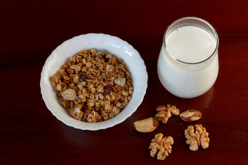 healthy Breakfast: a glass of milk, a Cup of muesli and nuts