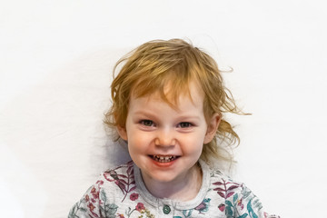 Little girl of three years old, looking at the camera and smiling.Defocused image.