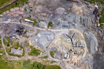 Aerial view of a small plant for the production and cleaning rubble and cement near the heaps of building materials, the tractors and trucks transports the finished product. Mining in quarry.
