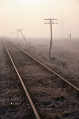 Fototapeta na wymiar Railway tracks on frozen misty morning