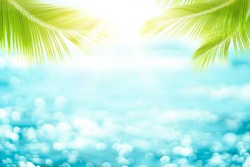 Obraz na płótnie Canvas Blur beautiful nature green palm leaf on tropical beach with bokeh sun light wave abstract background.