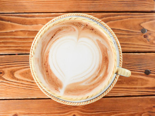 A Cup of hot latte art coffee on wooden table