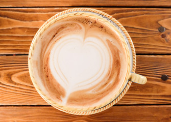 A Cup of hot latte art coffee on wooden table