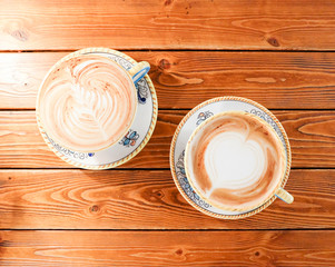 A Cup of hot latte art coffee on wooden table