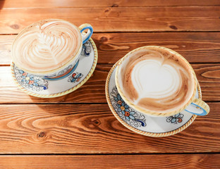 A Cup of hot latte art coffee on wooden table