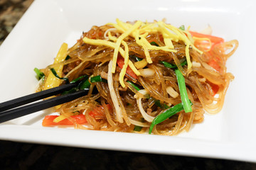 Korean dish called Japchae made from Noodles, stir fried in sesame oil with various vegetables.