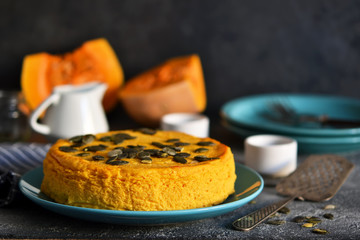 Pumpkin cheesecake on a concrete black background. Horizontal focus.
