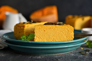 Pumpkin cheesecake on a concrete black background. Horizontal focus.