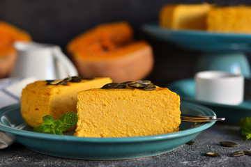 Pumpkin cheesecake on a concrete black background. Horizontal focus.