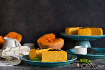 Pumpkin cheesecake on a concrete black background. Horizontal focus.