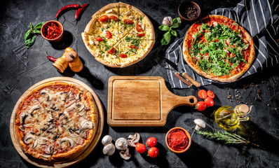 Three delicious traditional italian pizza, vegetables, ingredients on a dark background. Pizza menu