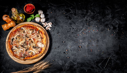 Traditional Italian pizza, vegetables, ingredients on a dark background. Top view with copy space....