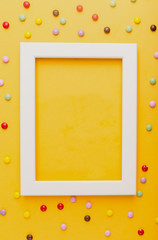 white frame on a yellow background with candies