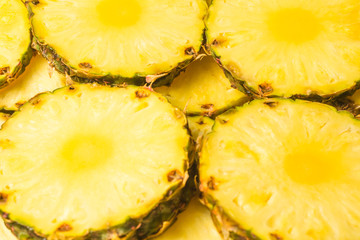 Pineapple juicy yellow slices background. Top view.