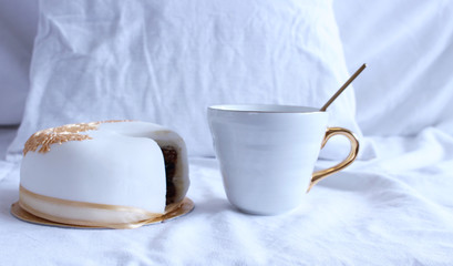 Cozy winter morning breakfast in bed still life scene. Steaming cup of hot coffee, tea and yummy cake. Christmas concept.