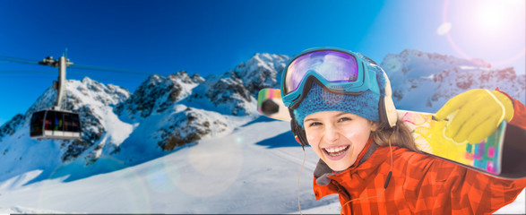 Portrait of happy young in the snow with ski in winter time, cable car and ski slope in the...