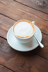 One cup of coffee on a wooden background.