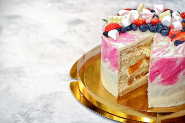 Layer cream cake with a slice cut out