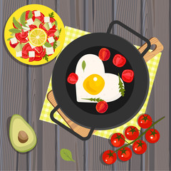 Heart shaped fried eggs in a pan, tomatoes and avocados
