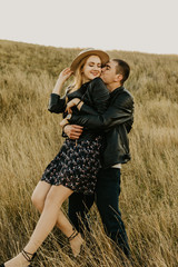 Happy young couple enjoying outdoors during sunset .