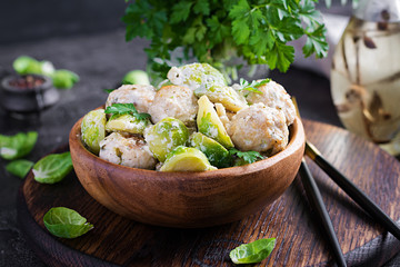 Brussels sprouts roasted with chicken meatballs and onions in a creamy sauce.