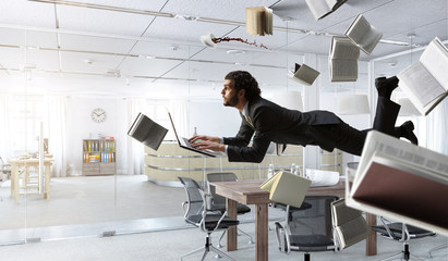 Man flies and works on laptop. Mixed media