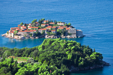 island and green peninsula.  houses with a tiled roof and green trees by the blue sea. happiness in relaxation in warm countries.