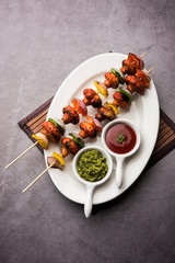 Barbecue or tandoori Mushroom Tikka, served in a plate with green chutney and ketchup. selective focus