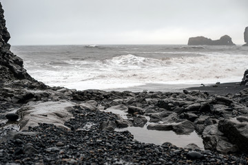 Black sand beach-schwarzer Strand in Südisland bei Vik, Lavasteine am sturmgepeitschten Strand