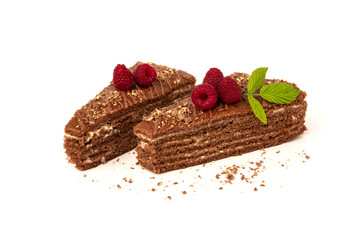 Slice of chocolate cake with milk filling and raspberry isolated on white background.