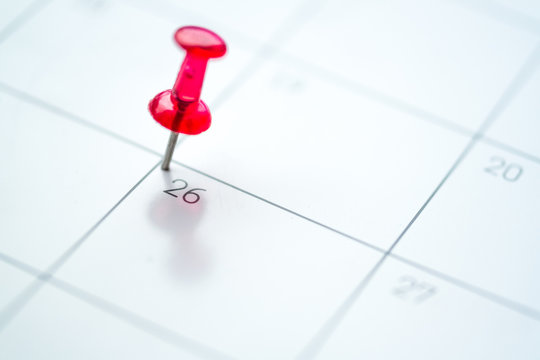 Red push pin on calendar 26th day of the month
