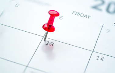 Red push pin on calendar friday the 13th day of the month