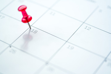 Red push pin on calendar 18th day of the month